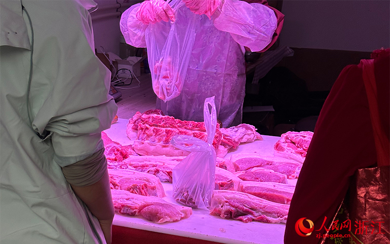 11月8日,杭州市上城区杨柳郡园四区沿街一家“农家土猪肉”店内透出紫红色灯光。人民网记者 叶宾得摄
